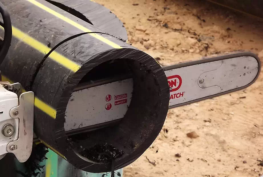 Using chainsaw to cut a pipe