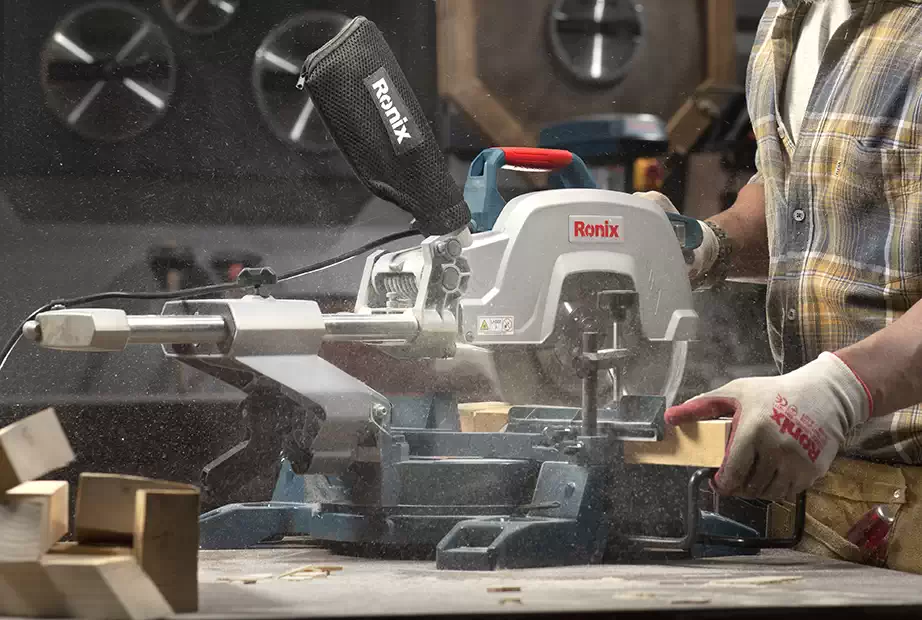 A man using a Ronix miter saw to cut wood