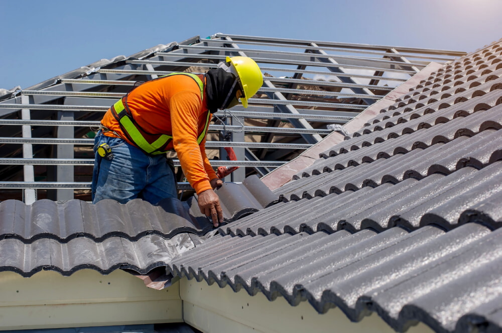 Roofer installing a metal roof at at construction site