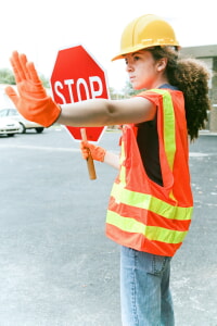 Lady working at a construction site stopping traffic